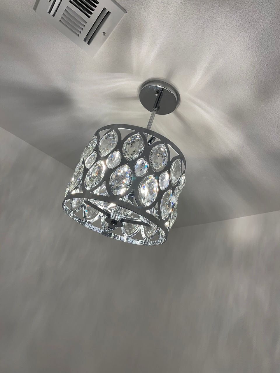 Illuminated geometric ceiling fixture casting a patterned shadow