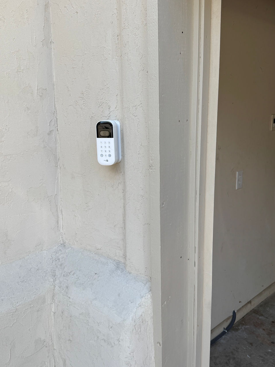 Wall-mounted exterior keypad beside a garage opening
