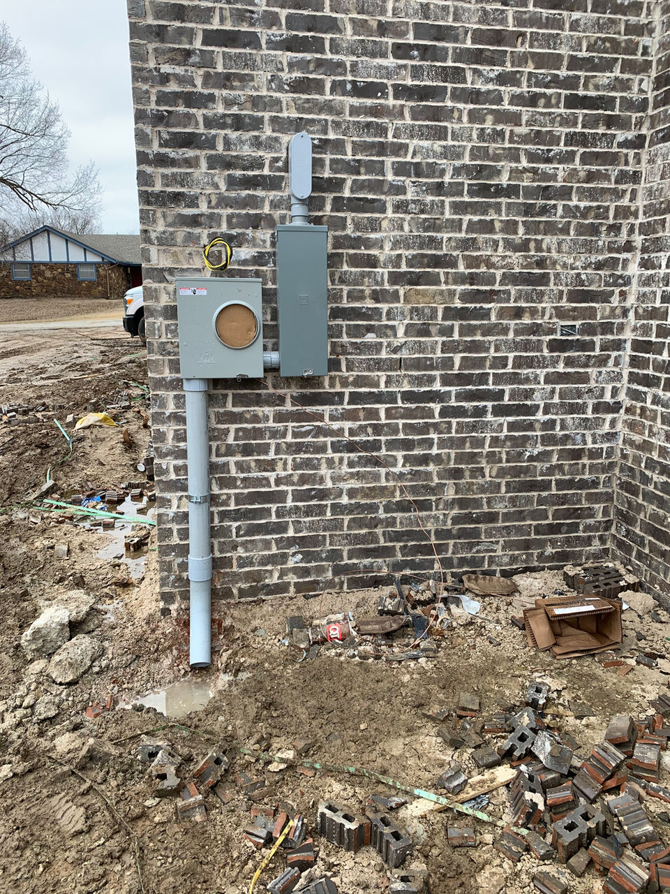 Meter equipment and conduit on the corner of a brick home