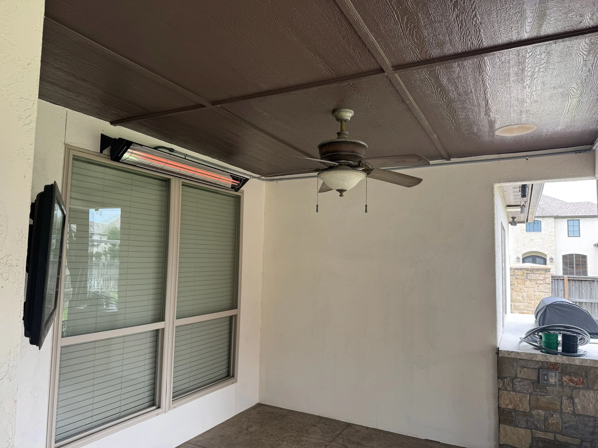 Ceiling fan beneath the finished ceiling of a covered outdoor patio