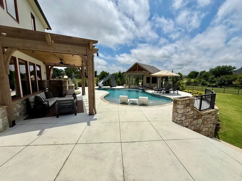 Finished backyard with a swimming pool, covered seating patio, and timber pavilion