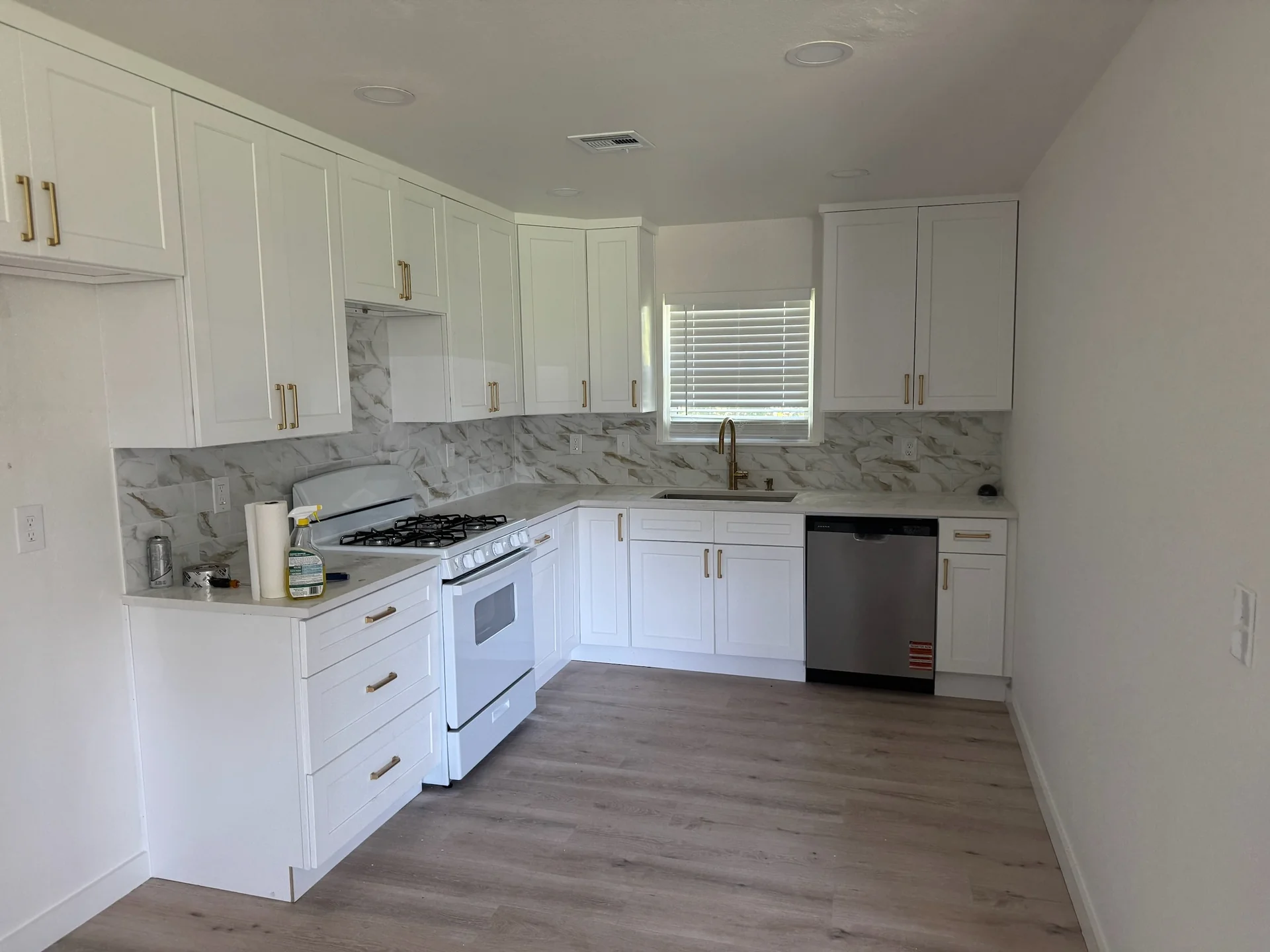 White kitchen with recessed ceiling lights and countertop receptacles