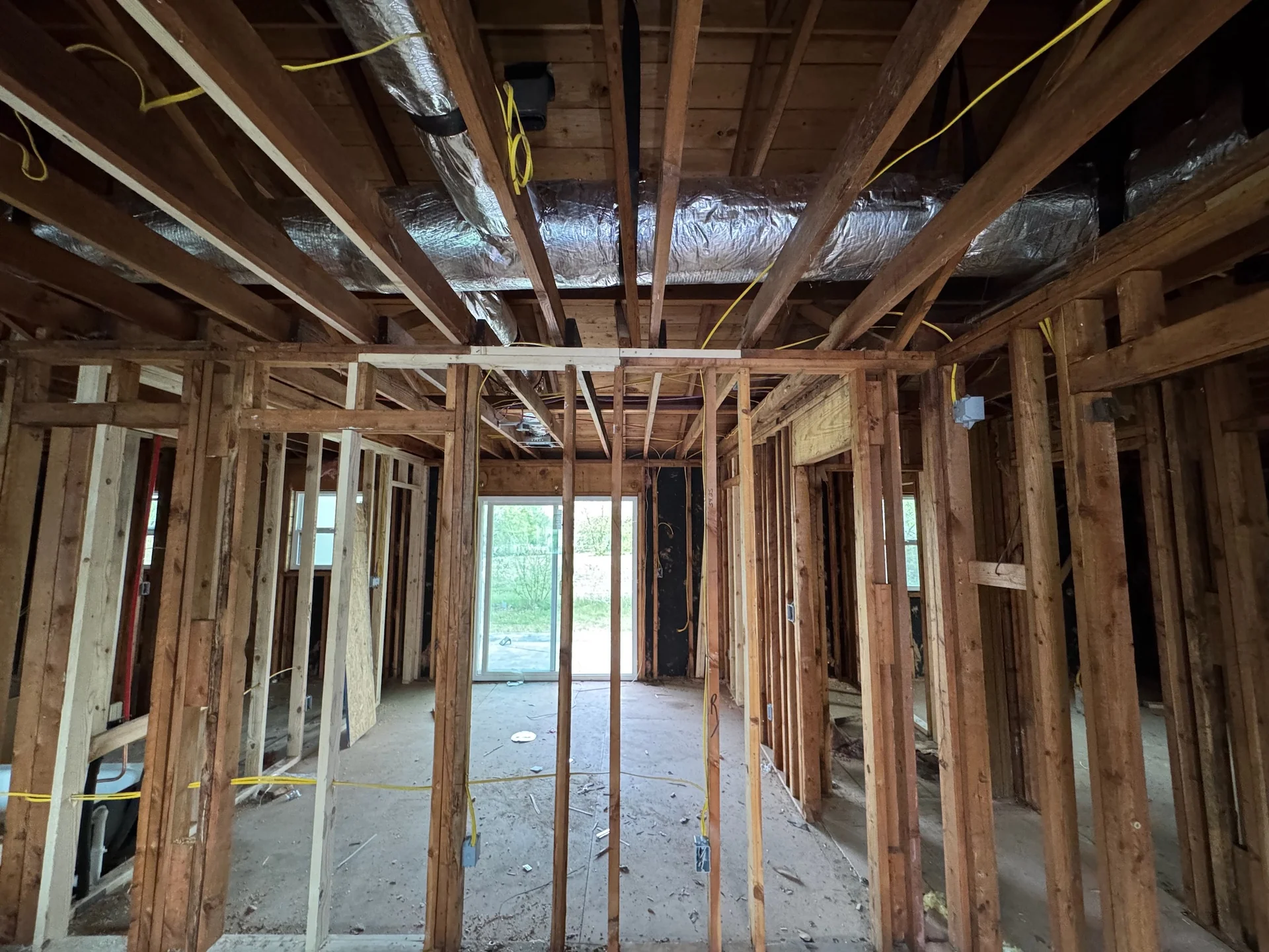 Electrical cables and device boxes within exposed wall framing during a home renovation