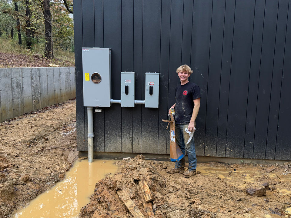 Fixed Electric team member beside exterior electrical equipment