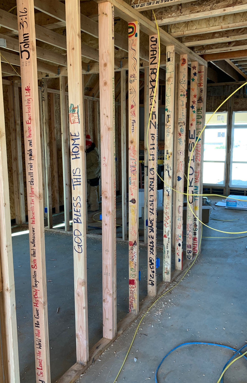 Bible verses and handwritten messages on exposed wall studs beside electrical wiring in the 2019 St. Jude house in Stone Canyon, Owasso